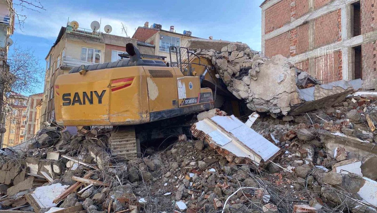 Ağır hasarlı binanın enkazı iş makinesinin üstüne yıkıldı