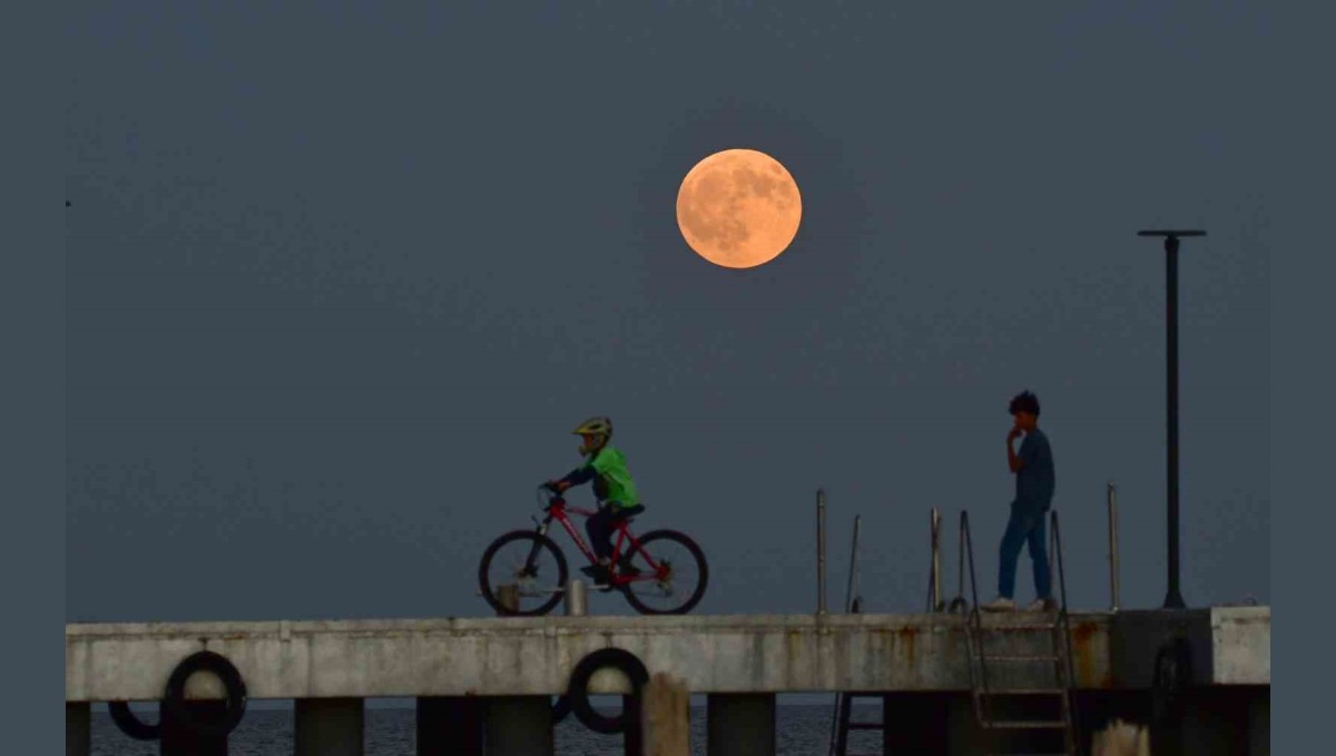 Dolunay ile insanların siluetleri aynı karede