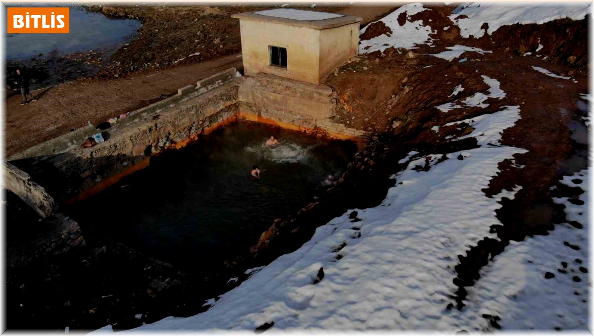 Etrafı karla kaplı doğal jakuzinin keyfini çıkarıyorlar