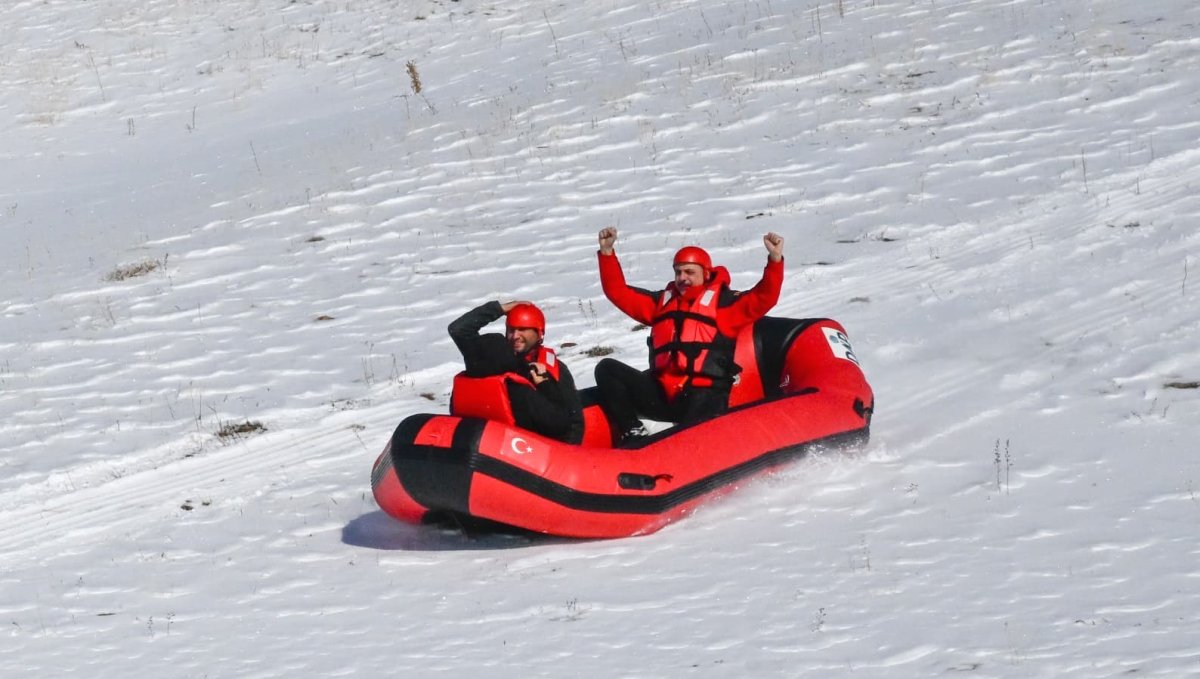 Karla kaplı dağdan donmuş gölete botla kaydılar