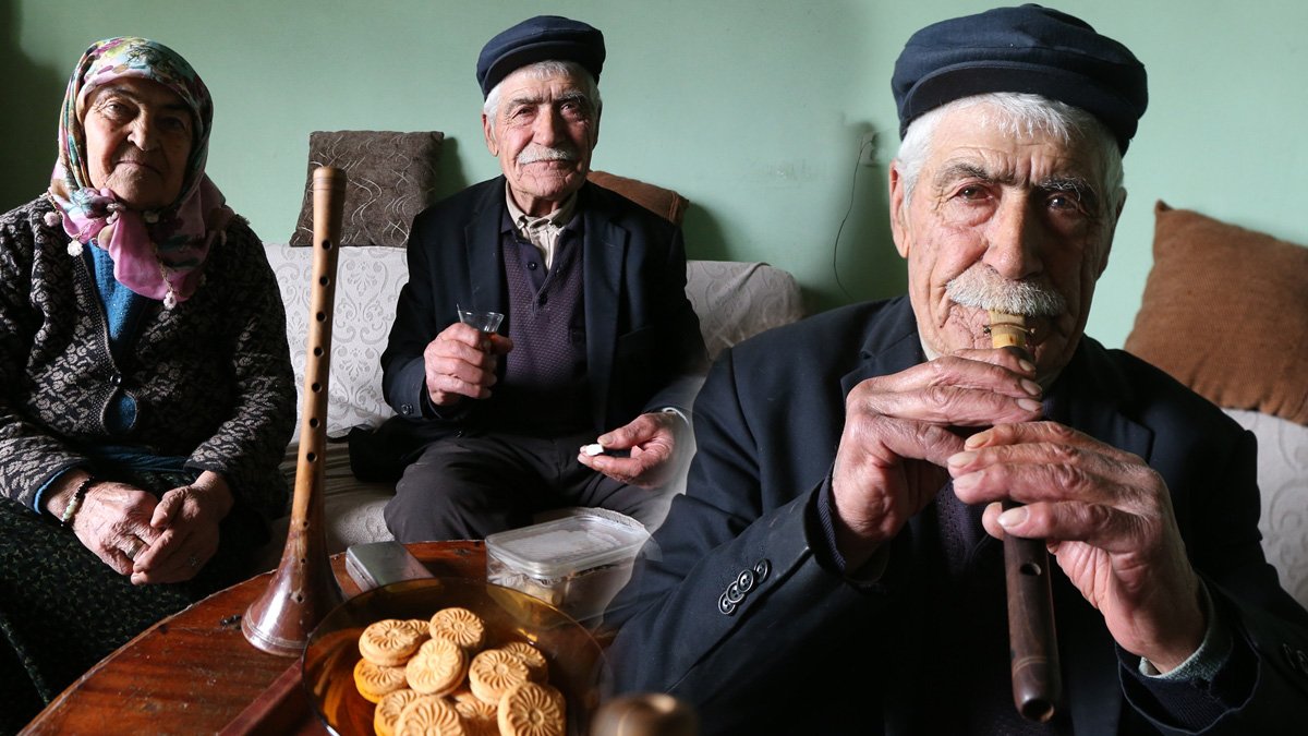 Karslı 82 yaşındaki Nazim Koç, acilde kolunda serumla mey çalıp hastalara moral verdi