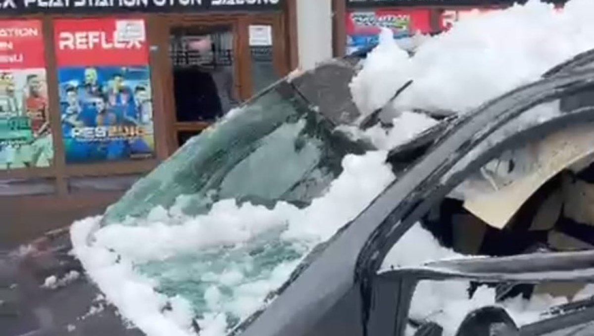 Park halindeki aracın üzerine çatıdan kar kütlesi düştü