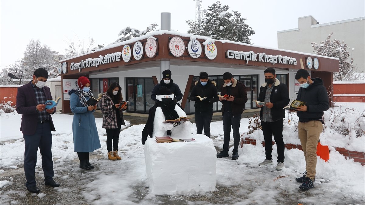 Vanlı gençler maske taktıkları kardan adamın etrafında kitap okudu