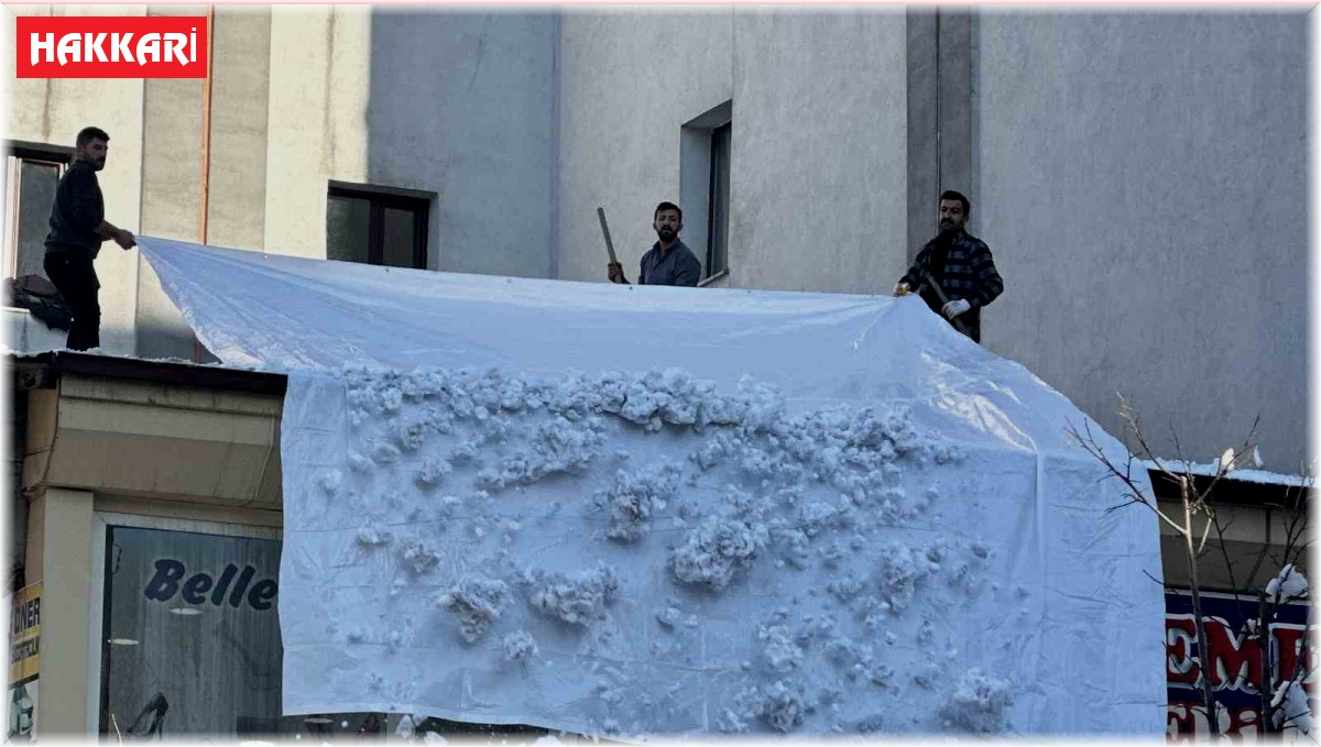 Vatandaşlar çatıdaki kar kütlelerini brandayla indirdi