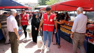 Pazar alışverişi yapan yaşlıların eşyalarını Kızılayın gönüllü gençleri taşıyor