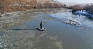 Dondurucu soğuğa rağmen nehirde buz parçaları arasında balık avlıyor