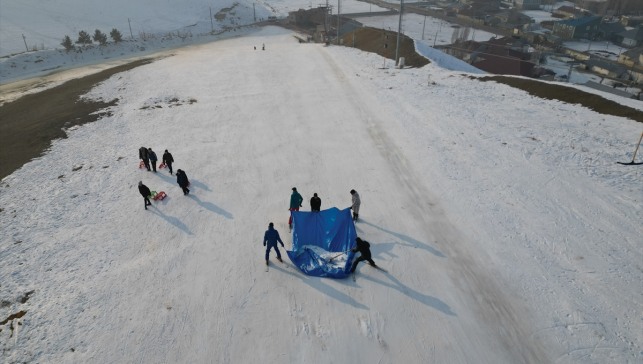 Ağrı'da kayak merkezinin erime yaşanan kısımlarına brandayla kar taşınıyor