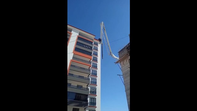 Beton pompasının üzerinde metrelerce yüksekliğe çıkan işçi, adeta ölüme meydan okudu