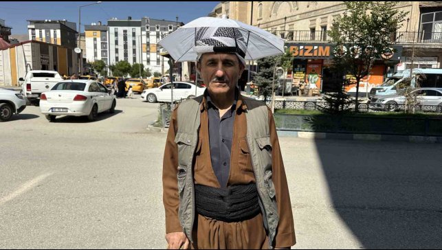Yüksekovalı vatandaş yıllardır kafa şemsiyesiyle güneşten korunuyor