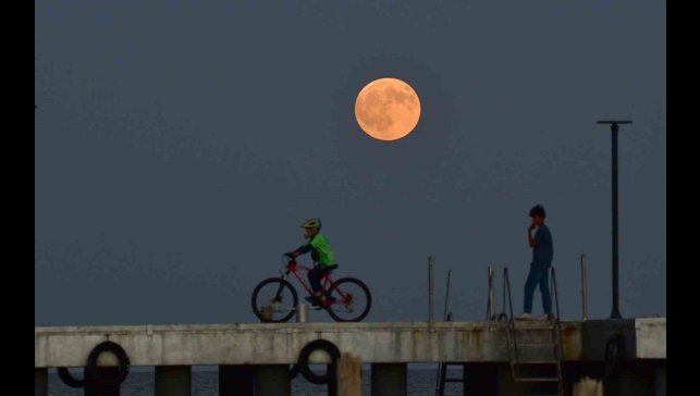 Dolunay ile insanların siluetleri aynı karede