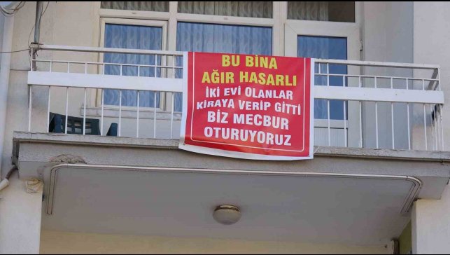 Ağır hasarlı pankartı asılan binayı görenler bir daha bakıyor