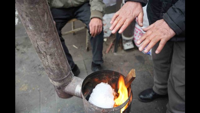 Erzincan pazarcısı soğukta sobayla ısınıyor