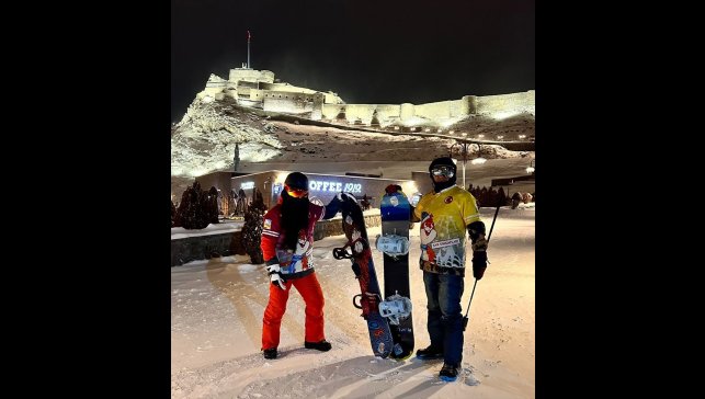 Karla beyaza bürünen Kars Kalesi'nden snowboardla kayarak indiler