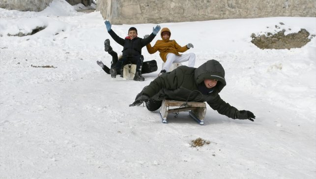 Kars'ta köy yolunu kızak pistine çeviren çocuklar karın keyfini yaşadı