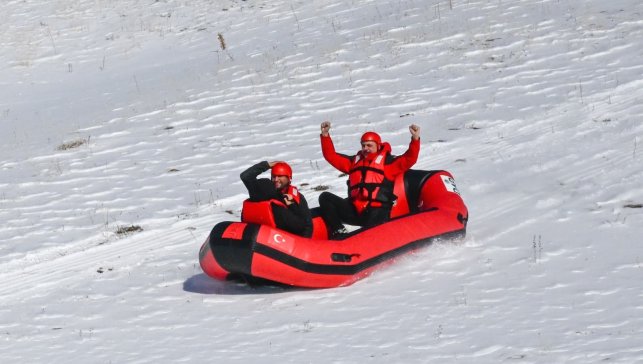 Karla kaplı dağdan donmuş gölete botla kaydılar