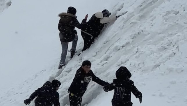 Yüksekova'da tepsiler kızak oldu, karlı yamaçlar oyun alanına dönüştü