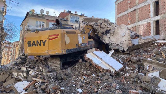 Ağır hasarlı binanın enkazı iş makinesinin üstüne yıkıldı