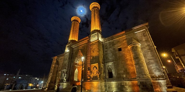 Bulutlar arasında süzülen ay ışığı Çifte Minareli Medrese'ye güzellik kattı