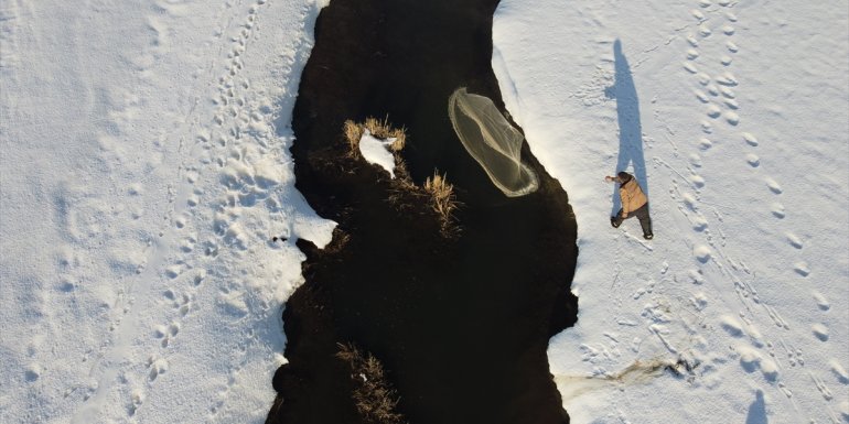 Karlar arasında kıvrılan mendereslerde dondurucu soğukta balık avı