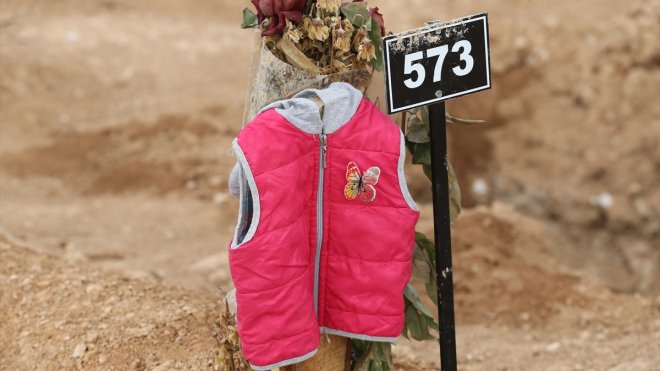Depremde hayatını kaybedenlerin eşyalarının kabirlerin üzerine konulduğu mezarlıkta hüzün