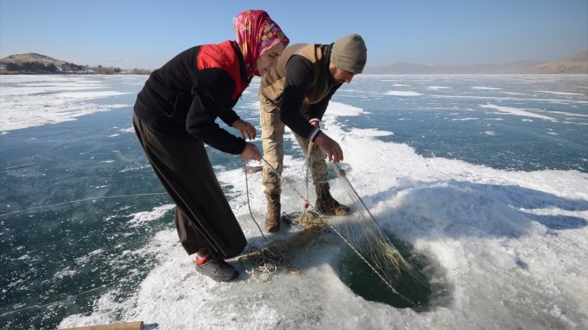 Eskimo usulü balık avlayan kadın, ekmeğini buzun altından çıkartıyor