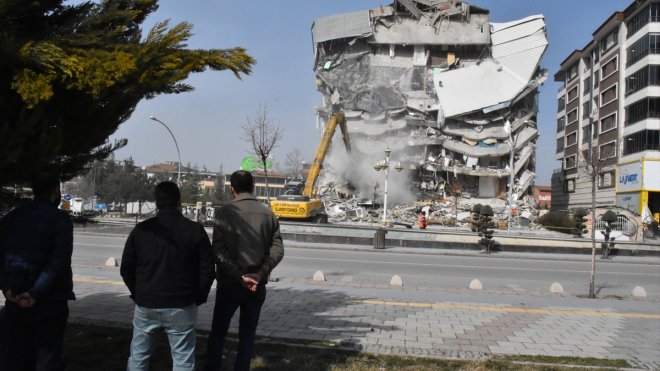 Apartmanlarının yıkımını izleyen depremzedeler, hatırası olan eşyalarını kurtarma umuduyla bekliyor