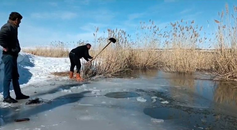 Yüzeyi donmuş nehirde buzu kırıp balık avlıyorlar1