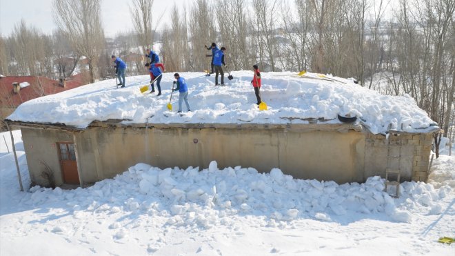 Hakkari'de gönüllü gençler yaşlı çiftin evinin damında biriken karı temizledi
