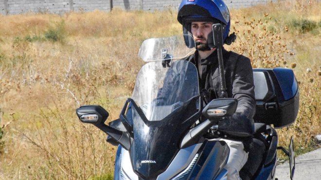 Motosikletiyle gittiği ücra mahallede çocuklara tatlı ikram ediyor