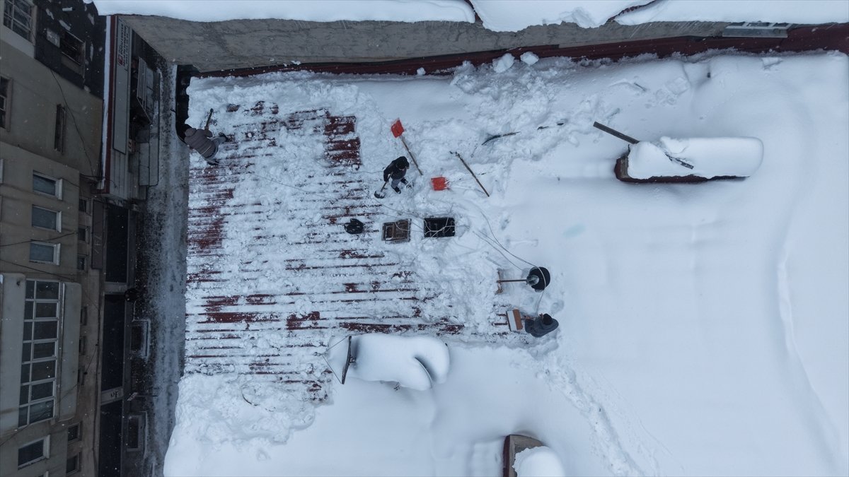 Muş'ta işçiler bellerine bağladıkları iple çatılarda kar temizliği yapıyor