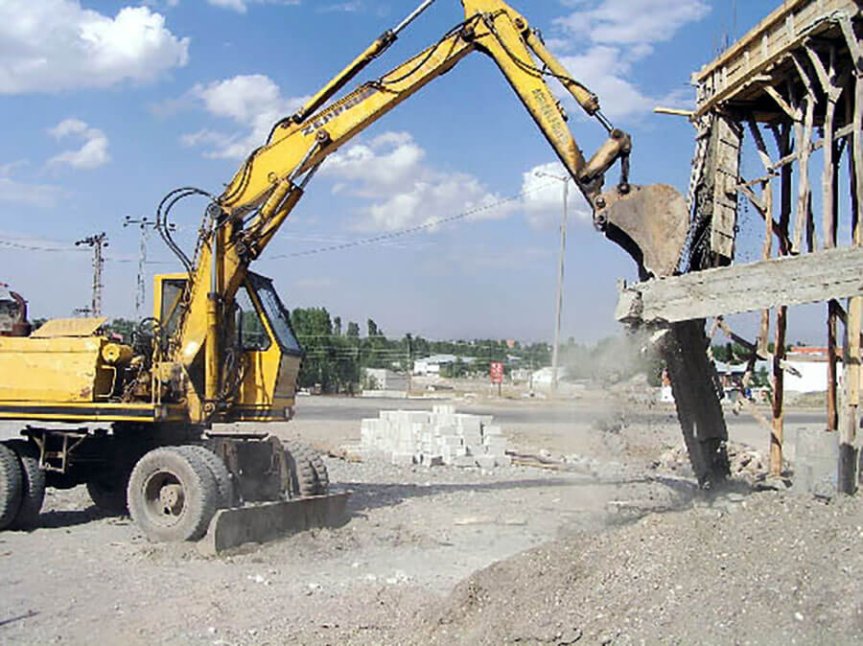 Ağrı'da belediye ekiplerinin ekskavatörle bina yıkımı çalışması