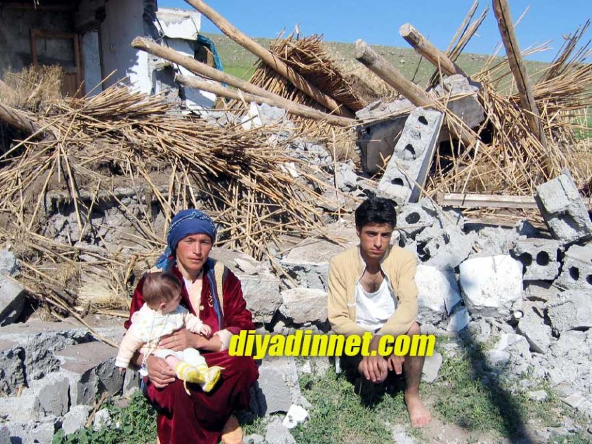 Ağrı Doğubayazıt depreminde hasar gören evin önünde oturan aile