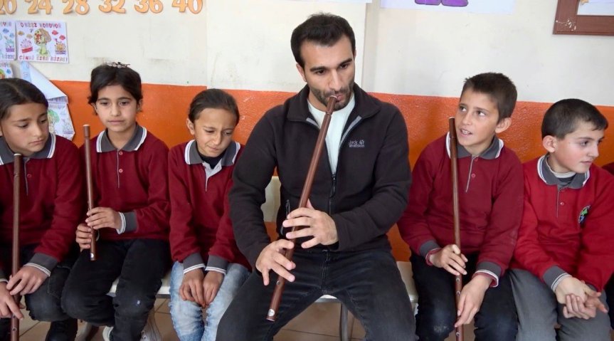 Öğrenciler, öğretmenleriyle birlikte kaval çalarak müzik etkinliğine aktif şekilde katılıyor.