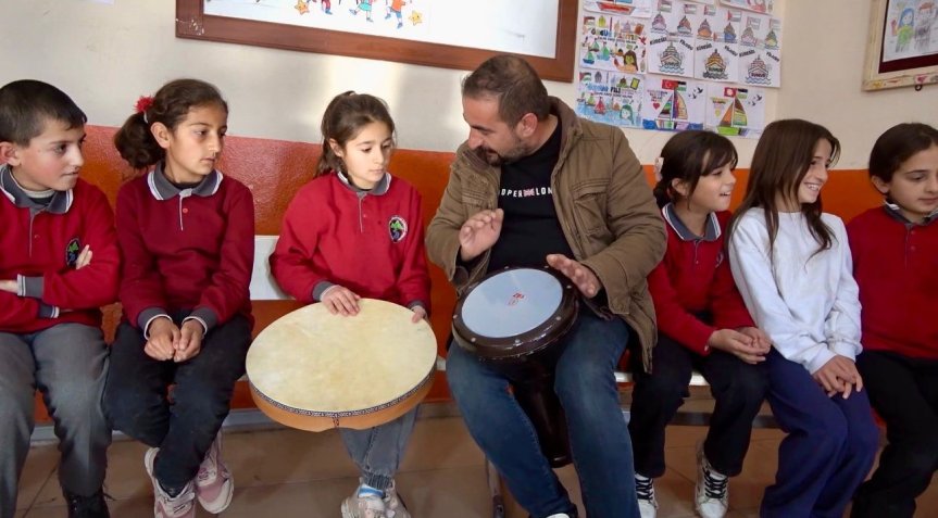 Kırsal okulda düzenlenen etkinlikte öğrenciler ritim çalgılarıyla müziği deneyimleme fırsatı buluyor.