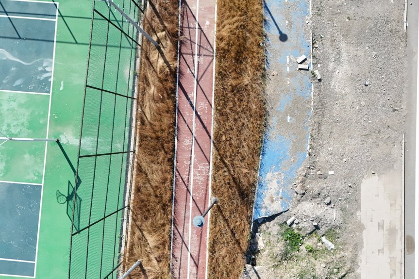 Spor sahasının yanındaki yürüyüş ve bisiklet yollarında kırık zeminler ile molozlar bulunuyor.