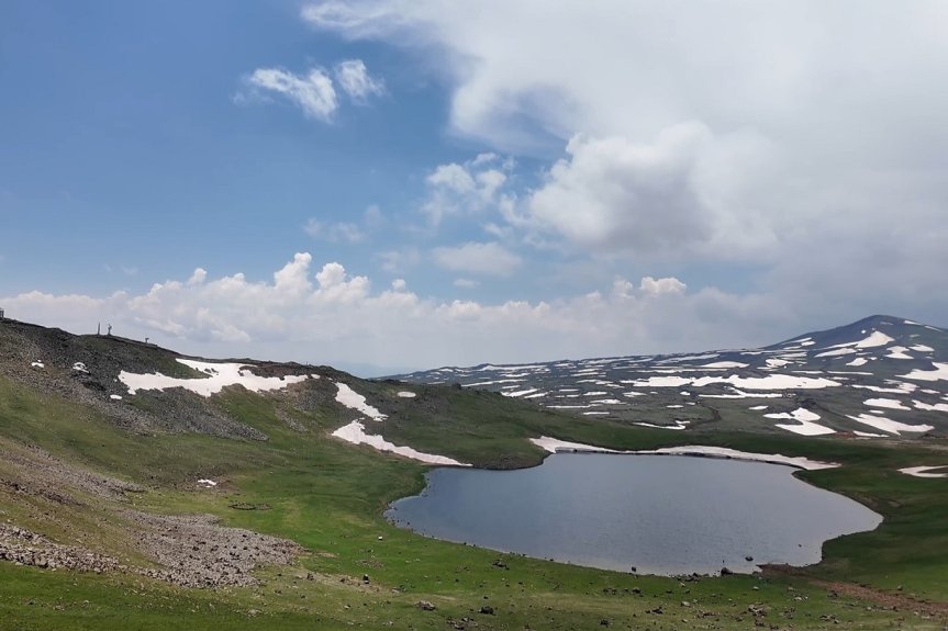 Krater gölü, yeşil yamaçlar ve kar parçaları Tendürek Dağı'nda eşsiz bir yaz manzarası sunuyor.