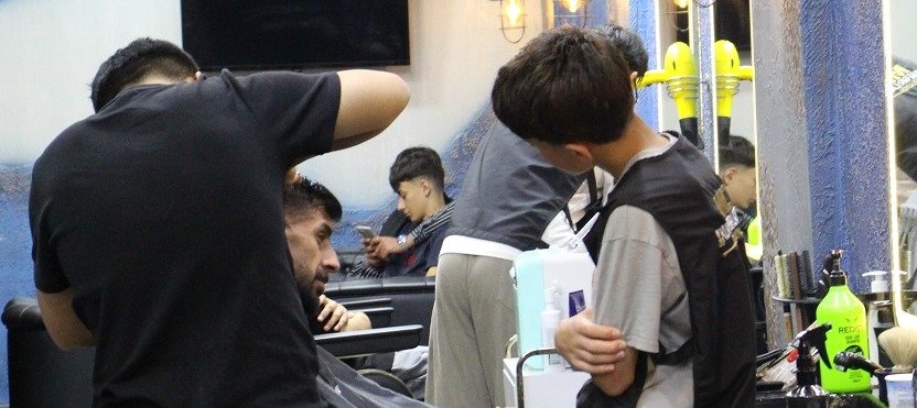 Ağrı'daki bir berber salonunda çalışanlar müşterilerine saç kesimi ve bakım hizmeti veriyor.
