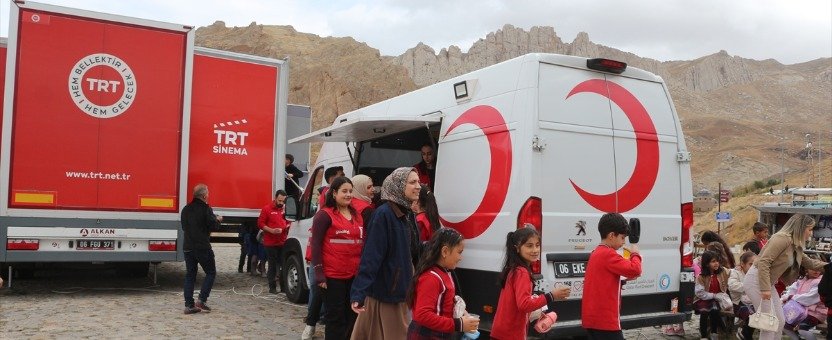İshak Paşa Sarayı önünde TRT Sinema Tırı ve Kızılay araçları çevresinde toplanan çocuklar