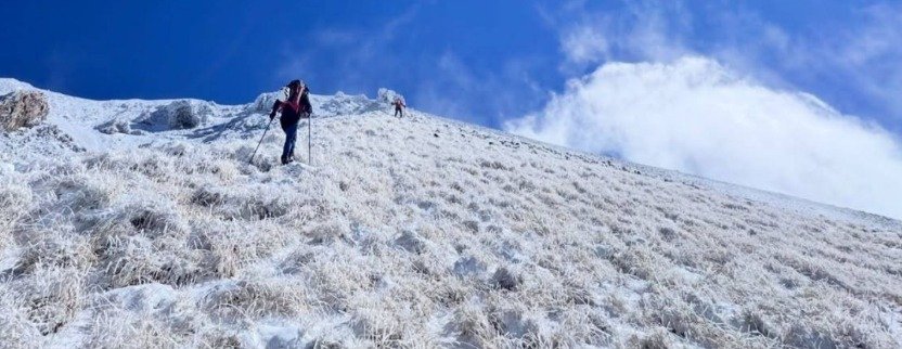 Küçük Ağrı Dağı'nın kar ve kırağıyla kaplı yamacında güneşli havada zirveye tırmanan iki dağcı.