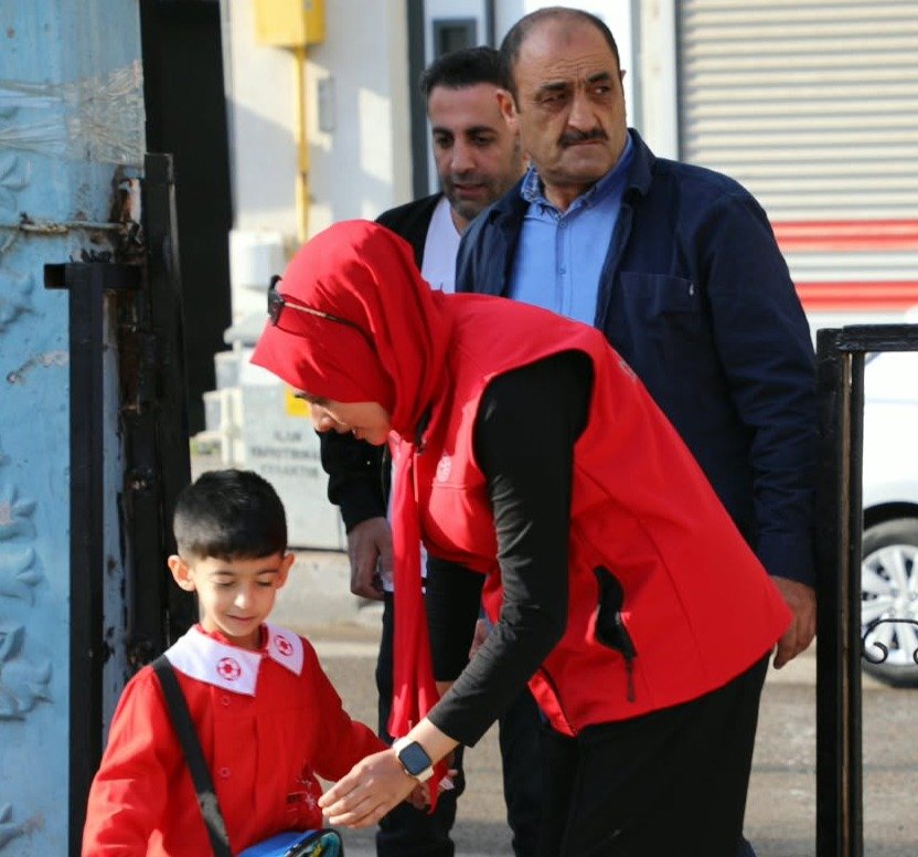 Okul bahçe görevlisi Ağrı'da okula gelen bir öğrencinin girişine yardımcı oluyor