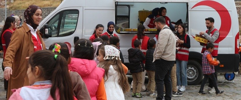 TRT Sinema Tırı'nın salonunda film gösterimi öncesi koltuklarda oturan çocuklar