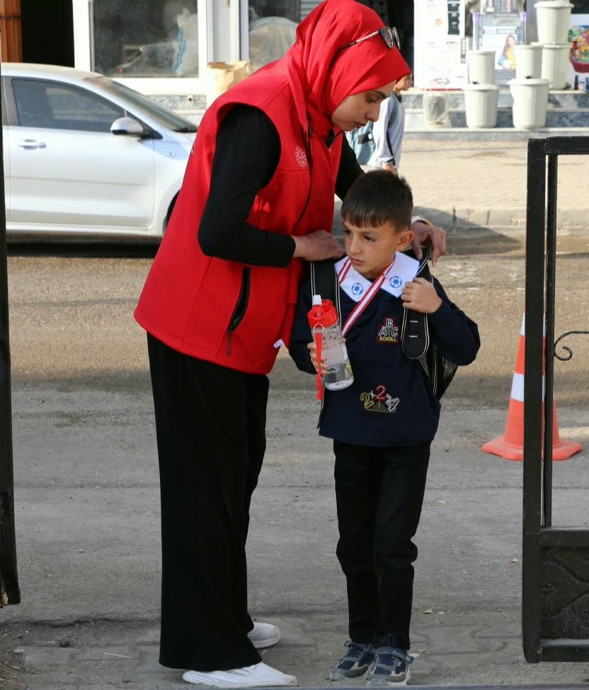 Ağrı'da okul bahçe görevlisi okul kapısında bir öğrencinin güvenliğine yardımcı oluyor